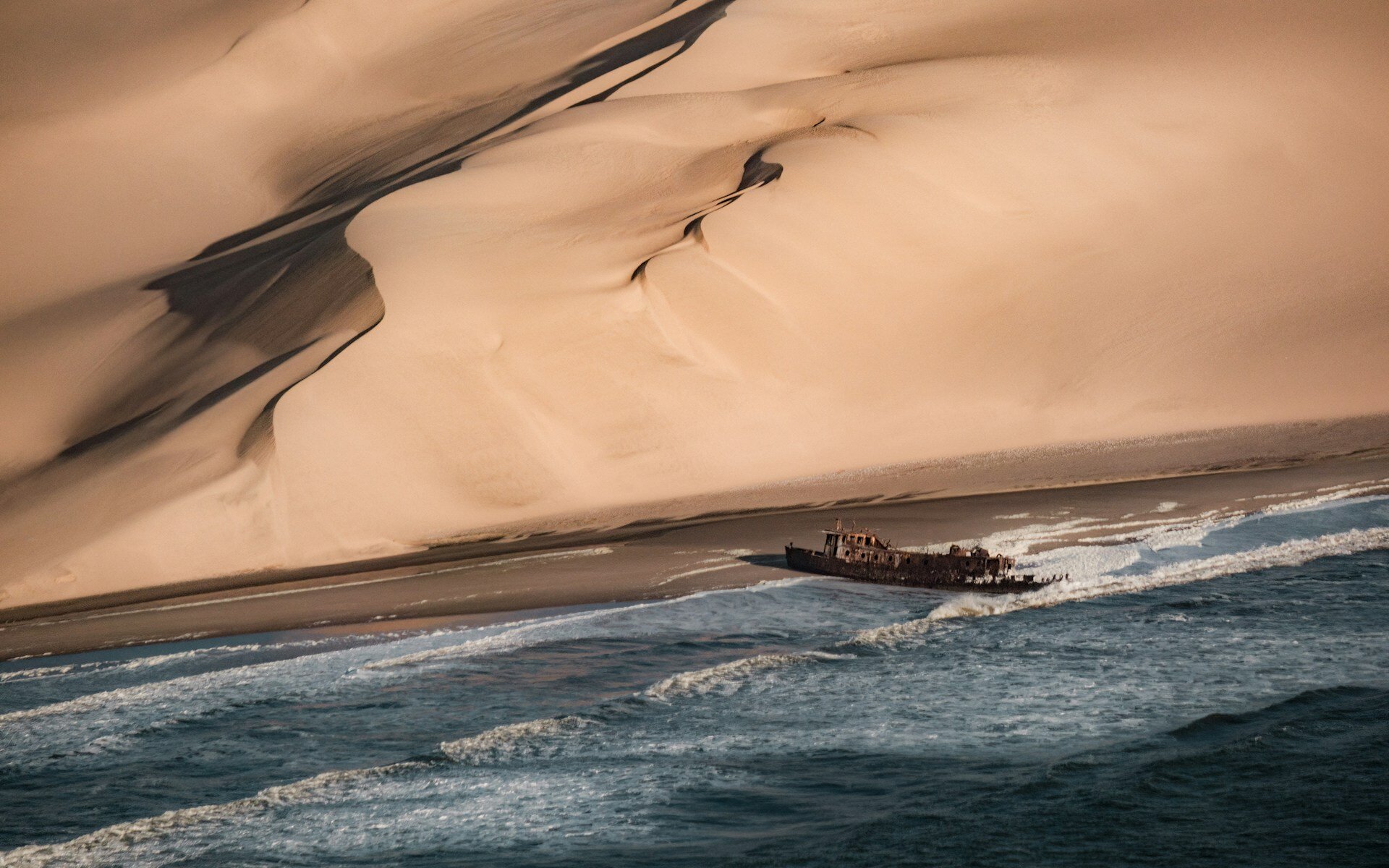 Skeleton Coast in Namibia mit einem angestrandeten Schiffswrack.