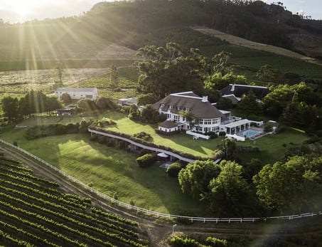 Hotel in den Weinbergen aus der Vogelperspektive bei tiefstehender Sonne.