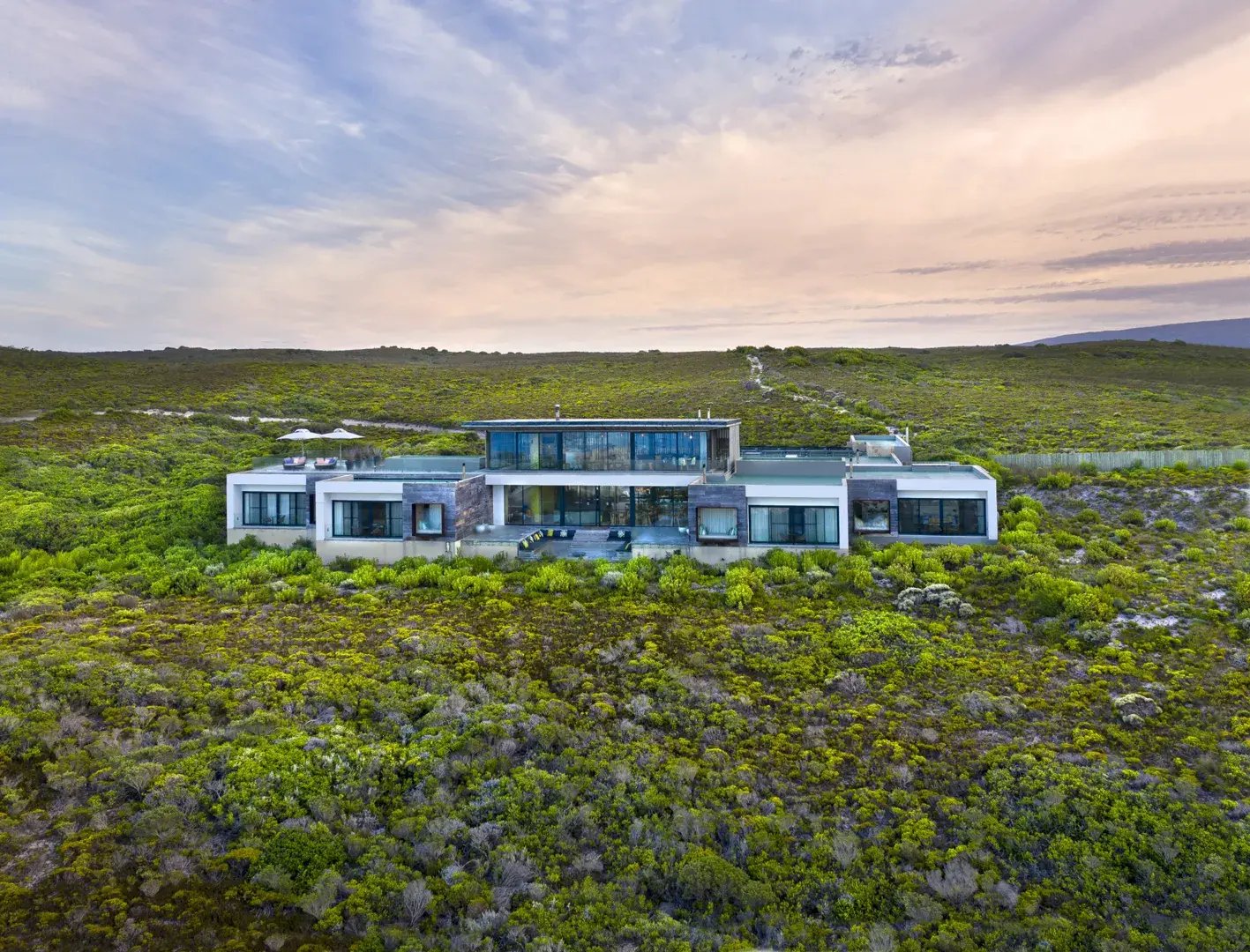 Außenansicht einer Beach Lodge, die inmitten saftig grüner Landschaft steht.