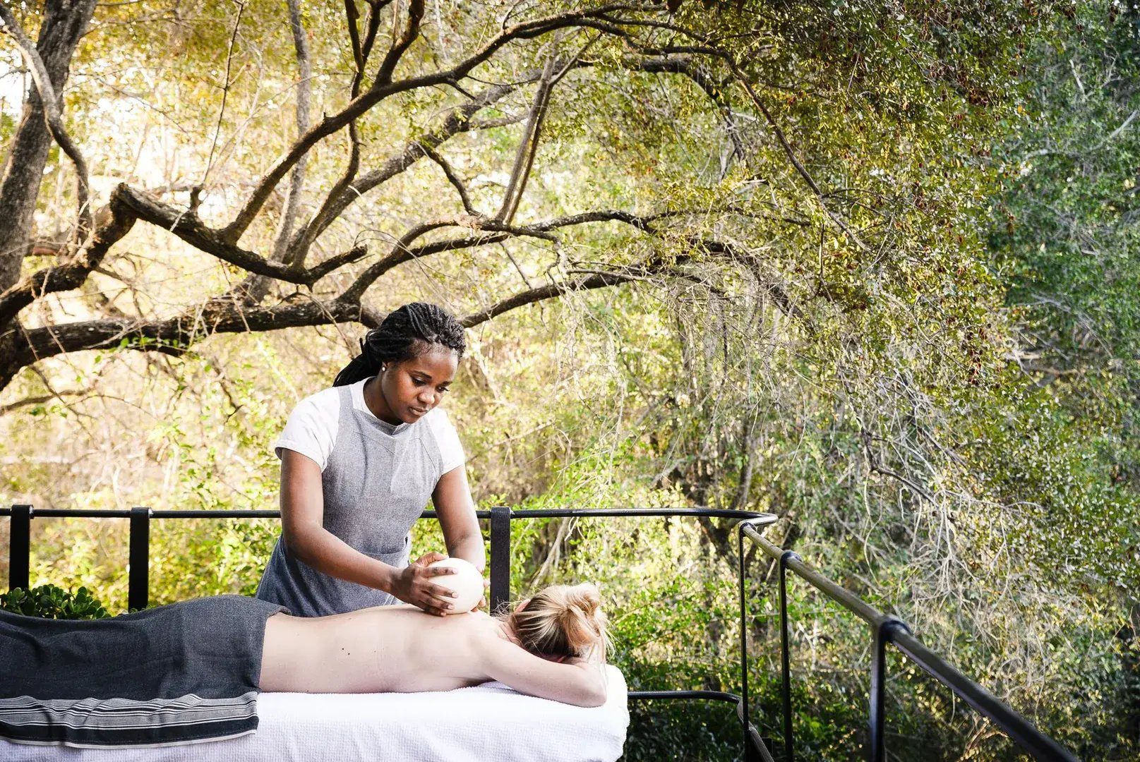 Eine Frau bekommt auf einer Terrasse eine Massage.