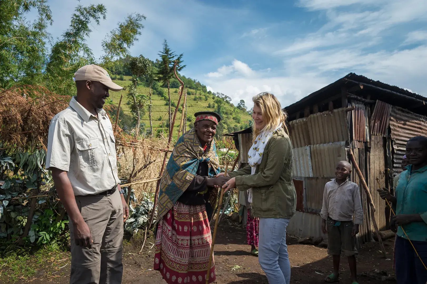 Eine Frau besucht mit einem Guide eine Dorfgemeinschaft in Ruanda.