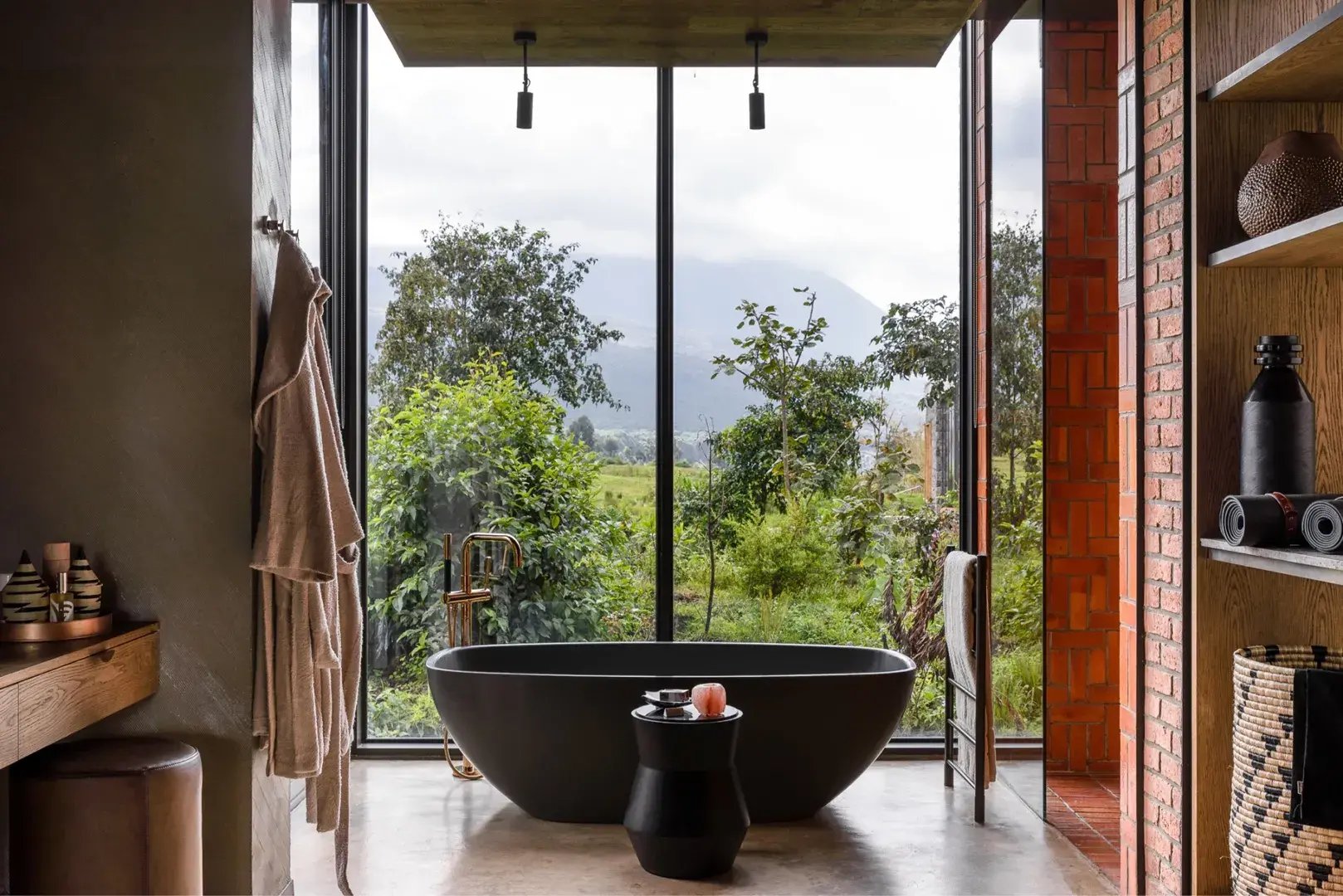 Freistehende Badewanne am Fenster mit Blick in die sattgrüne Natur.