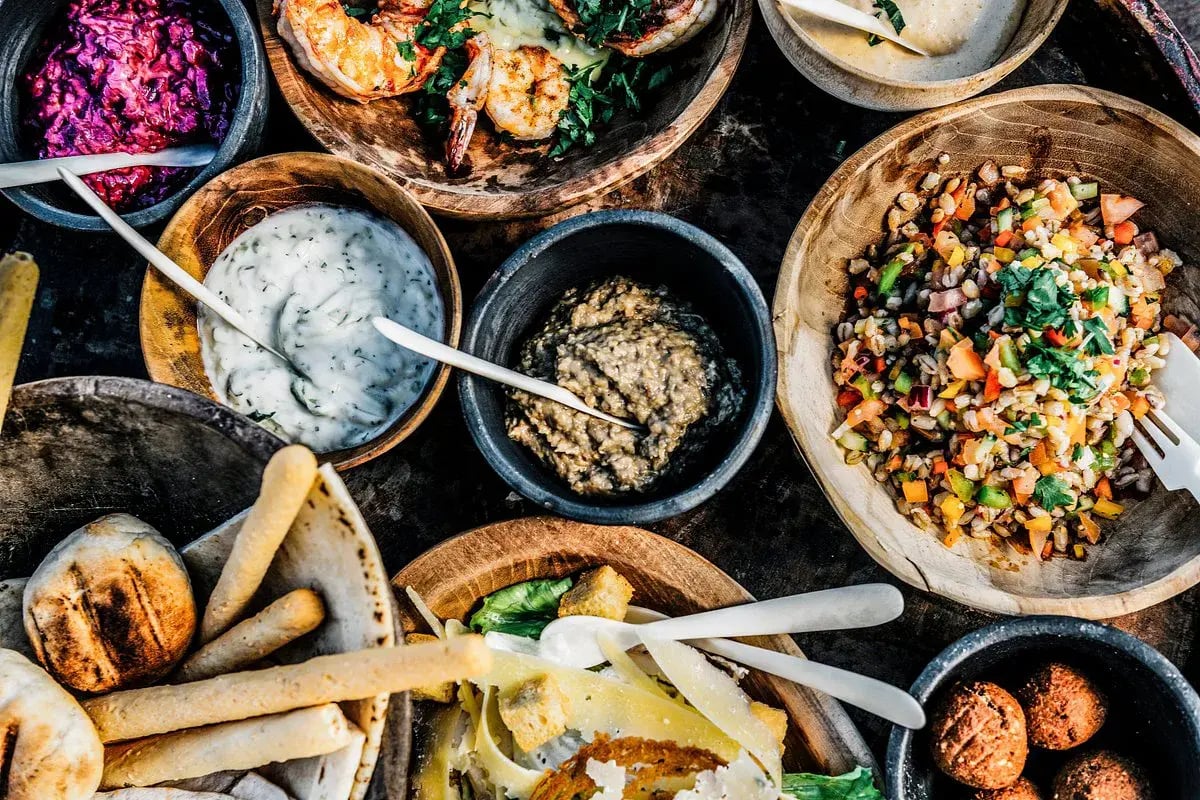 Tapas und Salate in kleinen Schalen angerichtet.