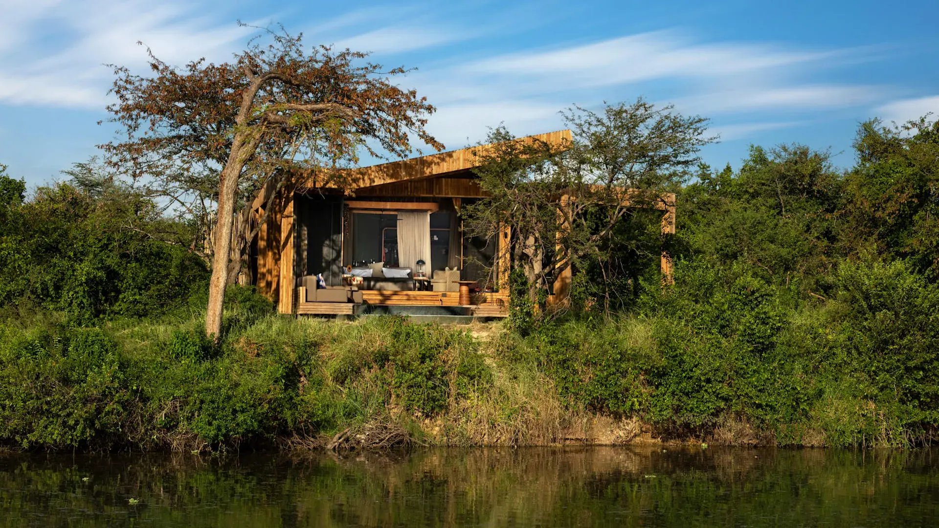 Lodge am Flussufer eingebettet in die Natur und umgeben von Bäumen.