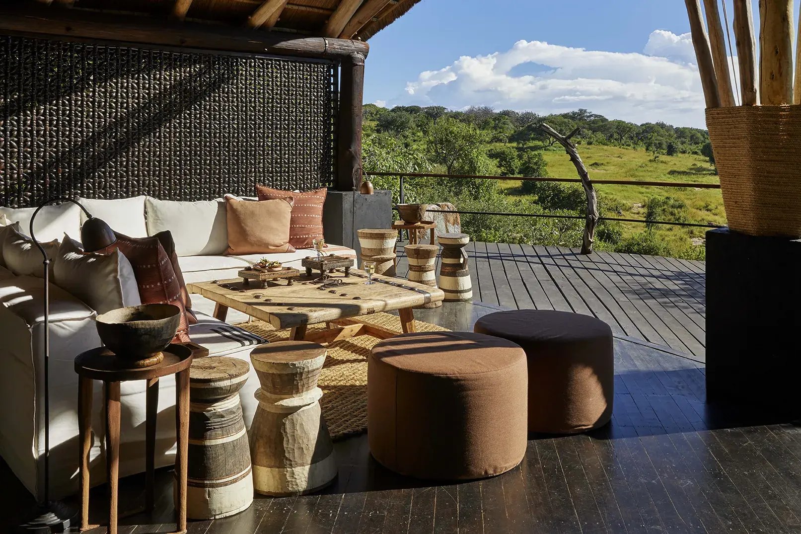 Überdachte Terrasse mit großem Ecksofa und Blick in die Savanne.