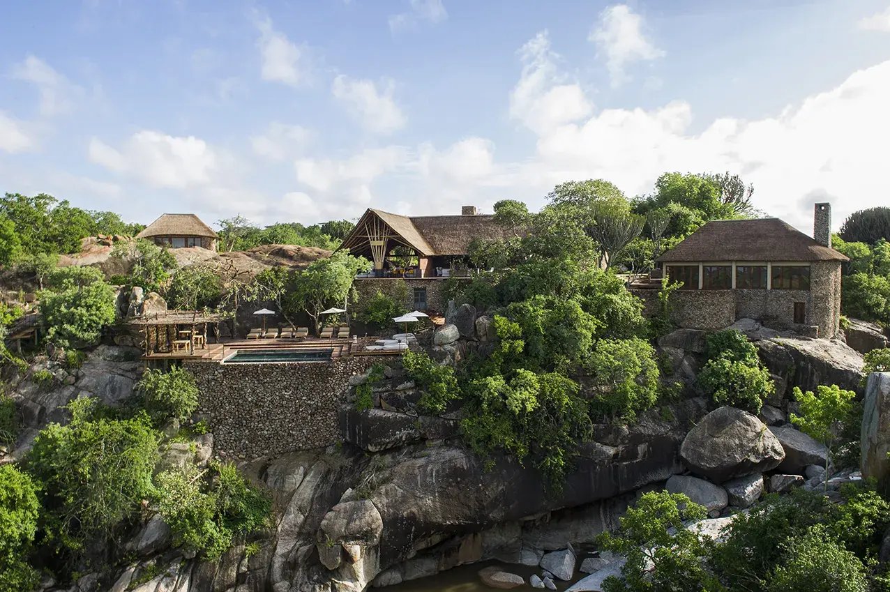 Außenansicht einer Luxuslodge, die auf Felsen gebaut wurde.