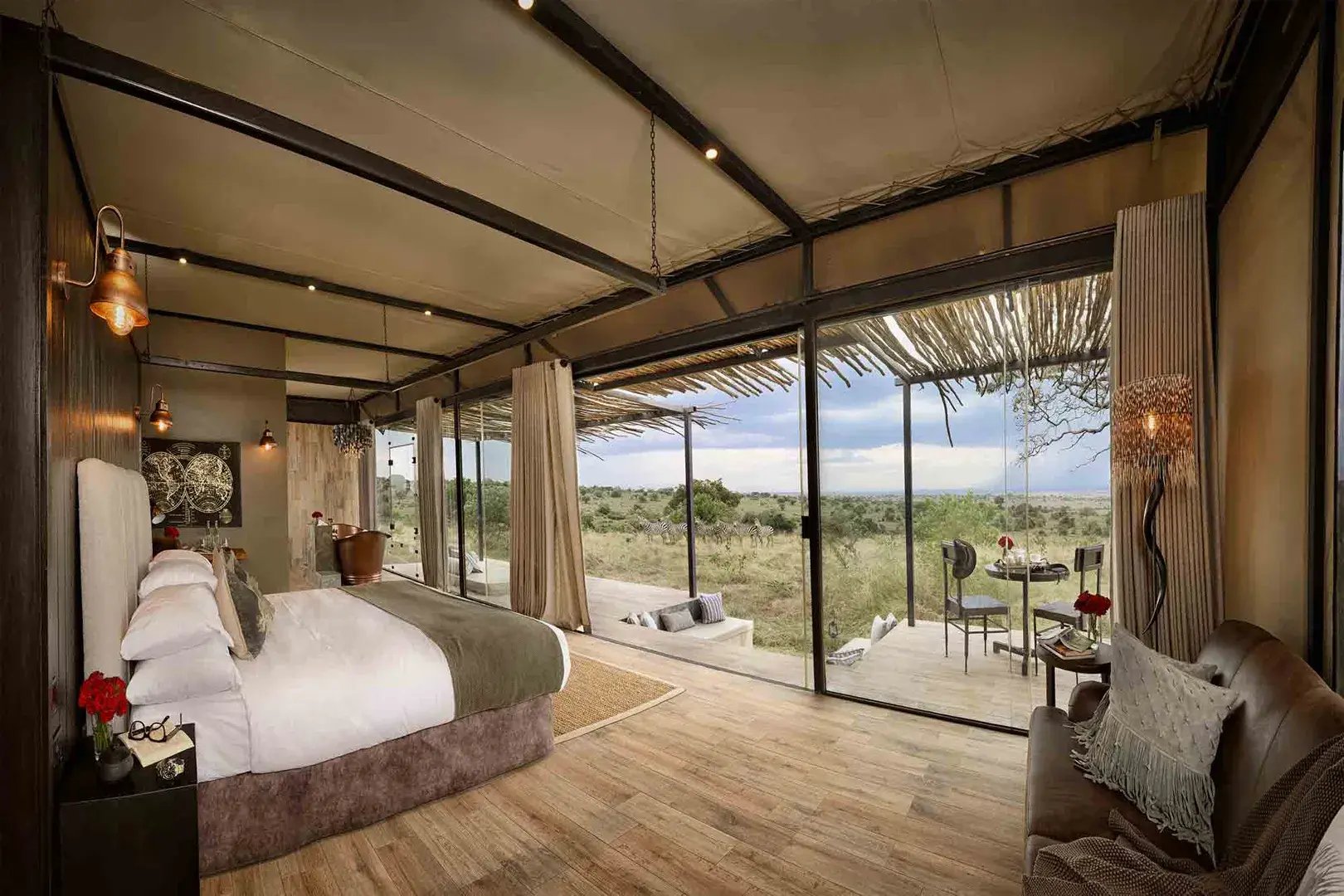 Große Luxuslodge mit Panoramafenster und Blick in die Serengeti.