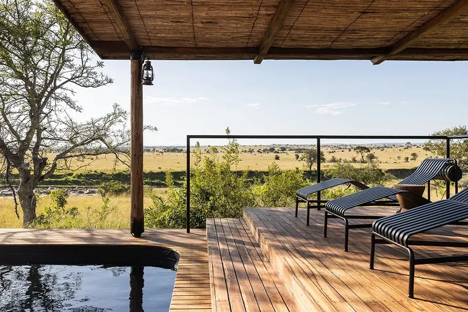 Sonnendeck mit Liegen, von dem aus man in die Serengeti blickt.