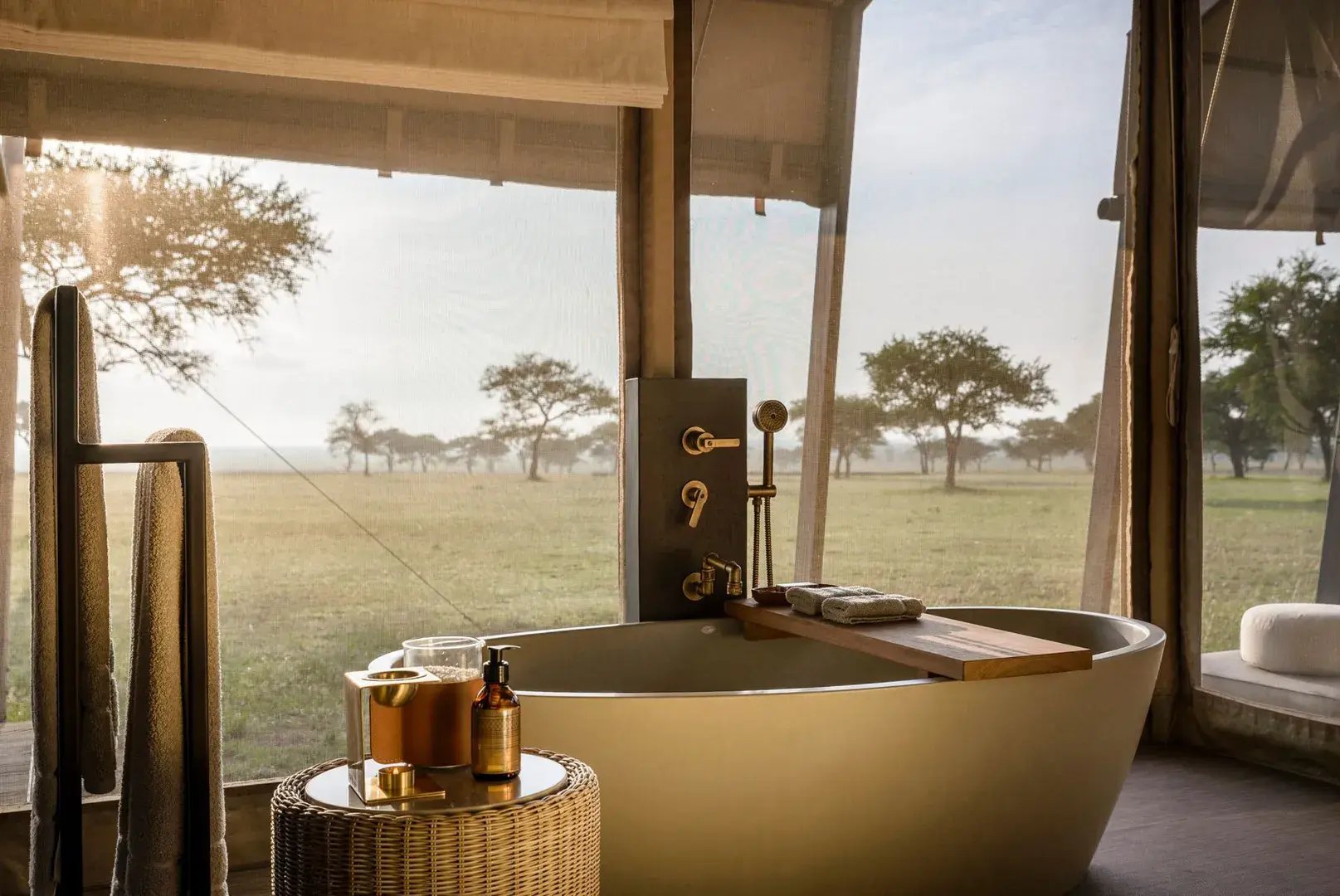 Freistehende Badewanne mit Auflage am Fenster eines Safari-Luxuszeltes in der Serengeti.