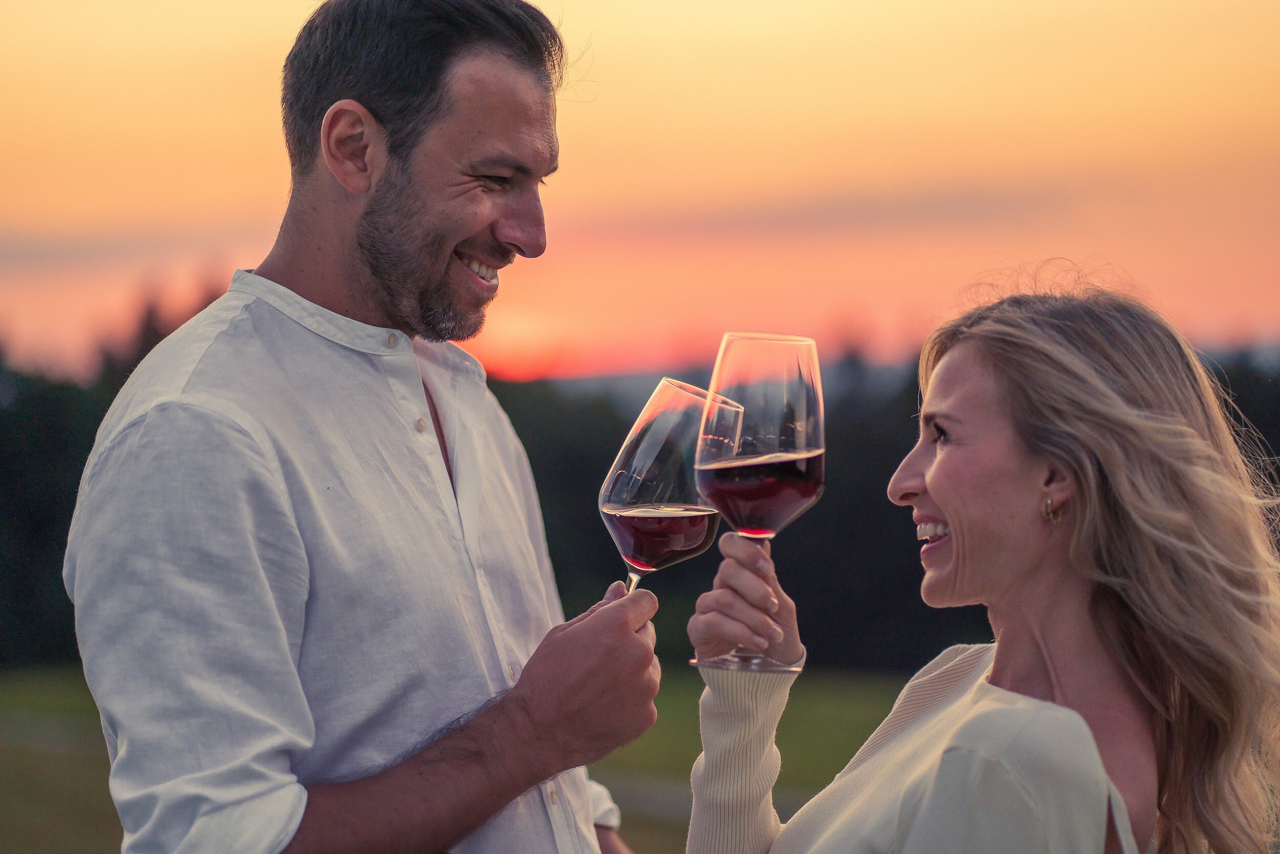 Pärchen mit Wein im Sonnenuntergang