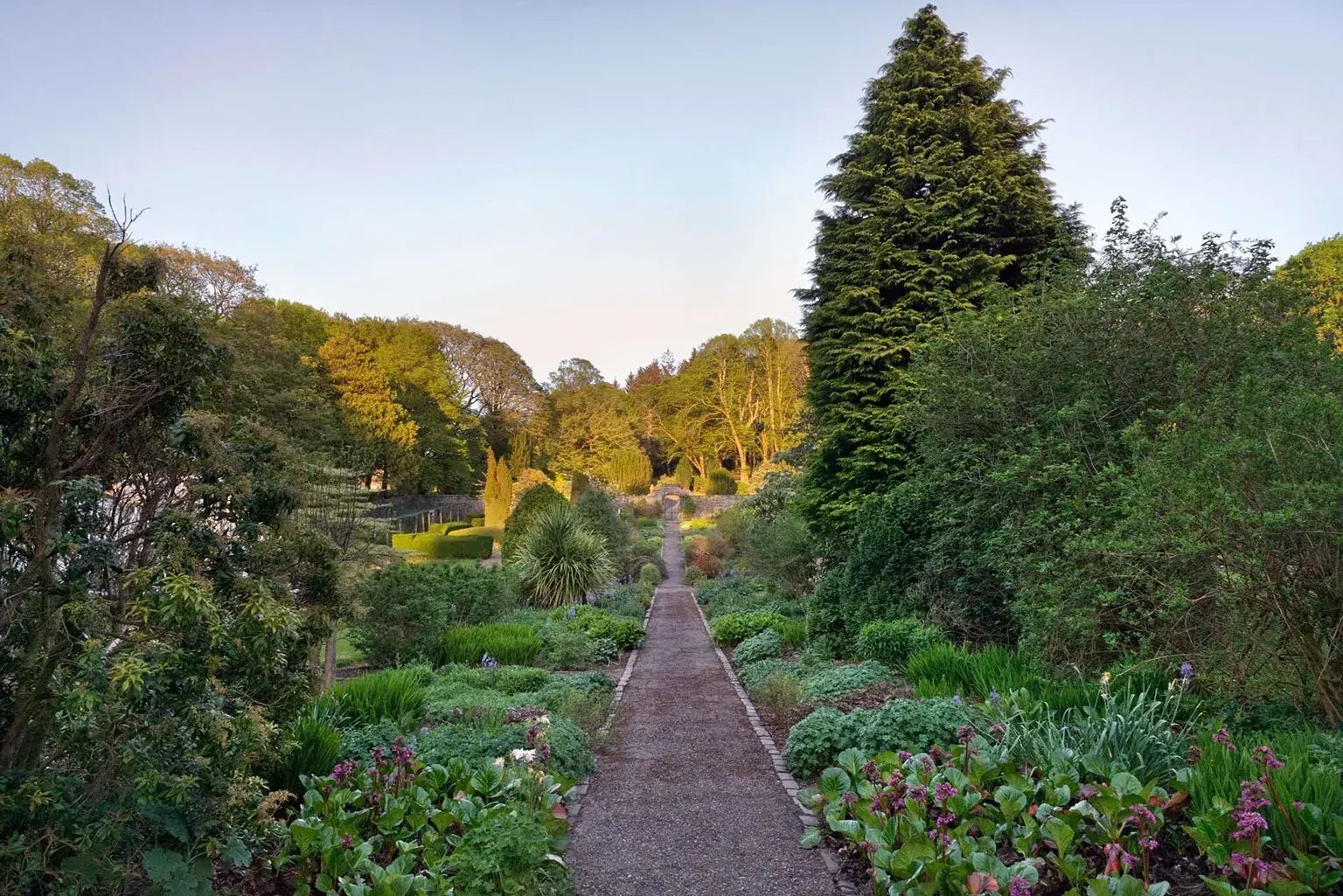 Weg führt durch einen üppig bewachsenen Garten.